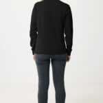 Femme portant un sweat noir et jean gris.