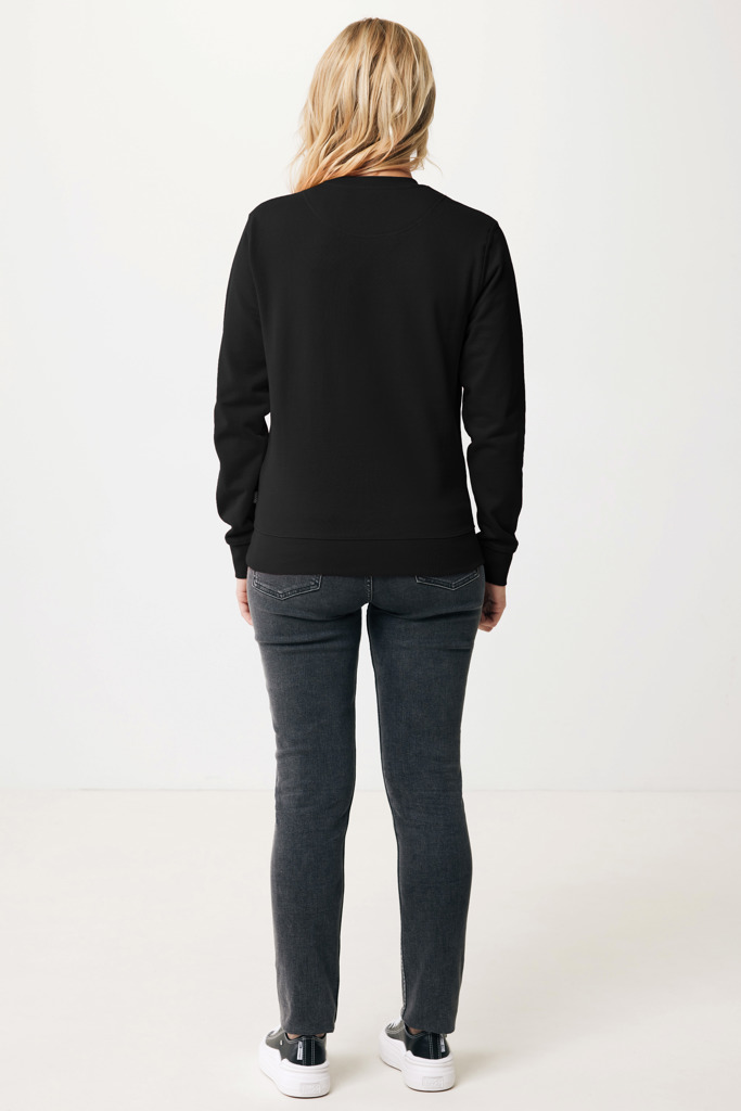 Femme portant un sweat noir et jean gris.