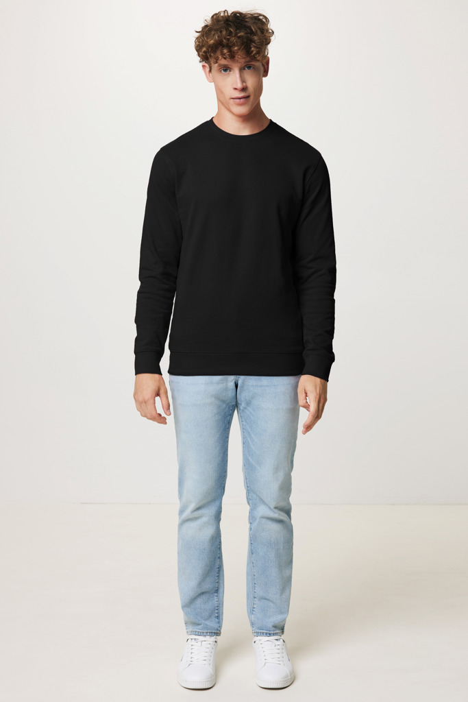 Homme portant un pull noir et jean clair