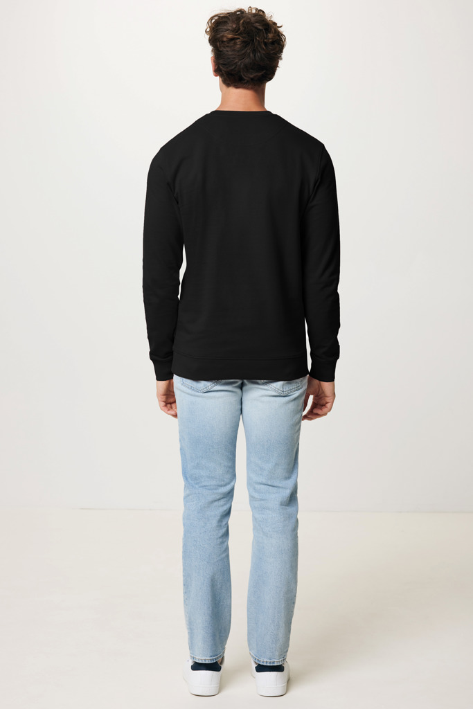 Homme portant sweat noir et jean clair