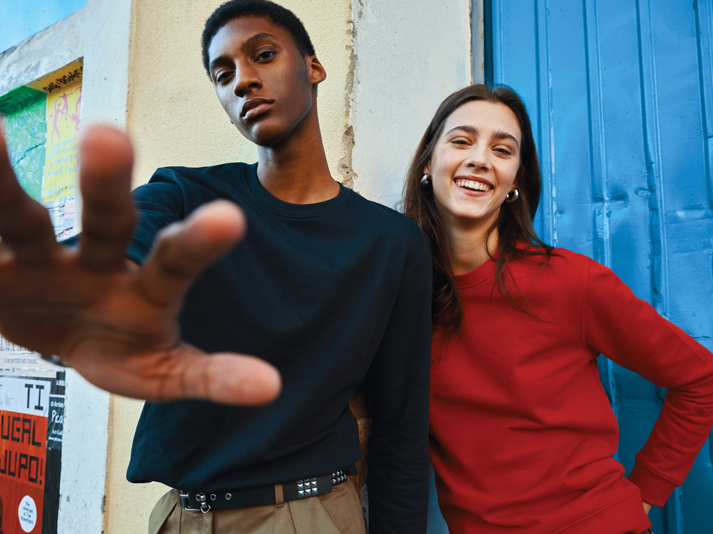 Deux amis posent joyeusement devant un mur coloré