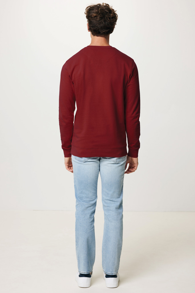 Homme portant un pull bordeaux et jean clair