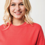 Femme souriante portant un pull rouge