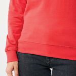 Sweat rouge et jean noir portés par une personne