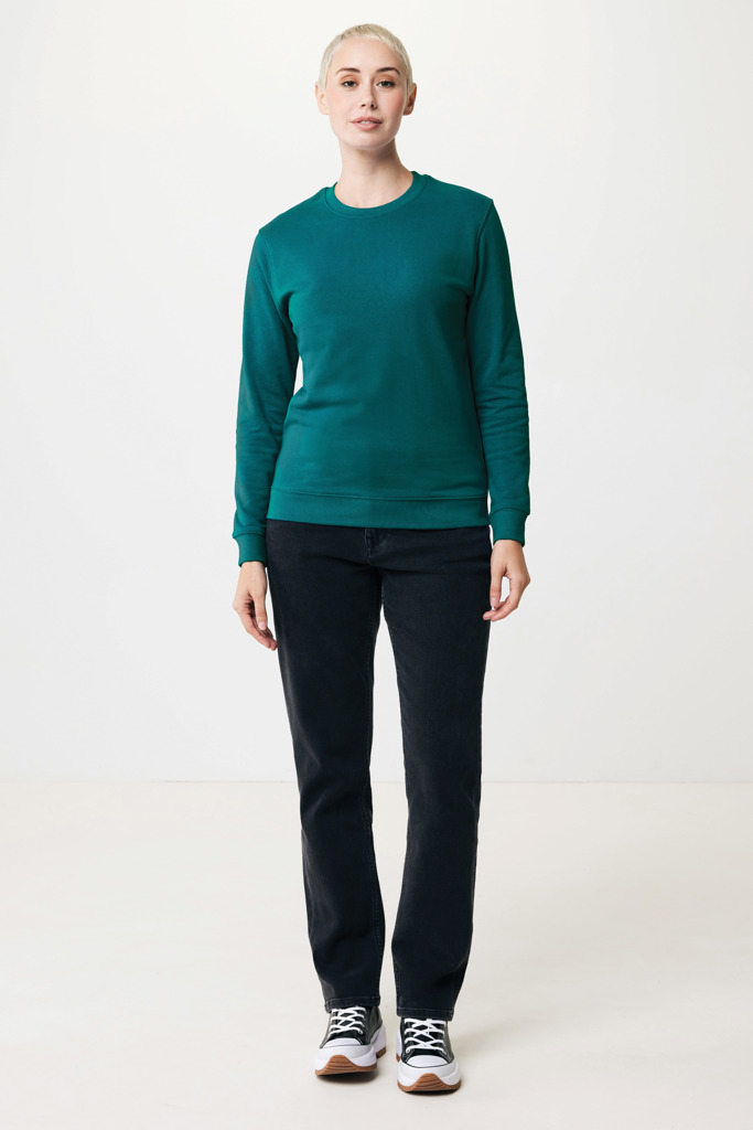 Personne portant un pull vert et un jean noir.