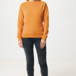 Femme portant un sweat orange et jean noir