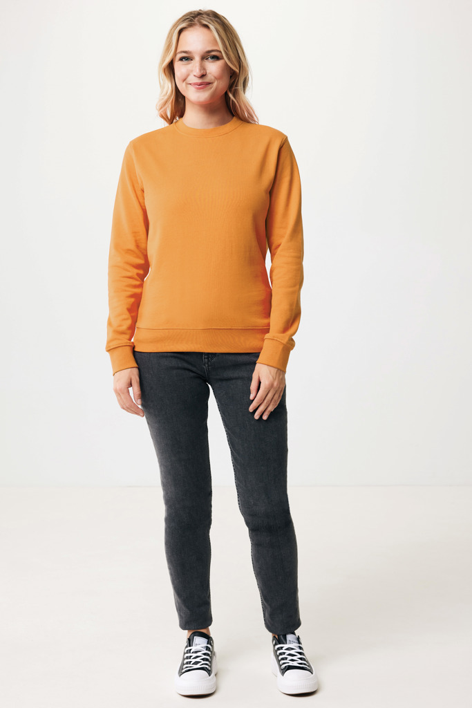 Femme portant un sweat orange et jean noir