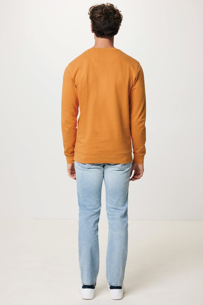 Homme portant un sweat orange et jean clair