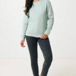 Femme portant un sweat vert et un jean noir