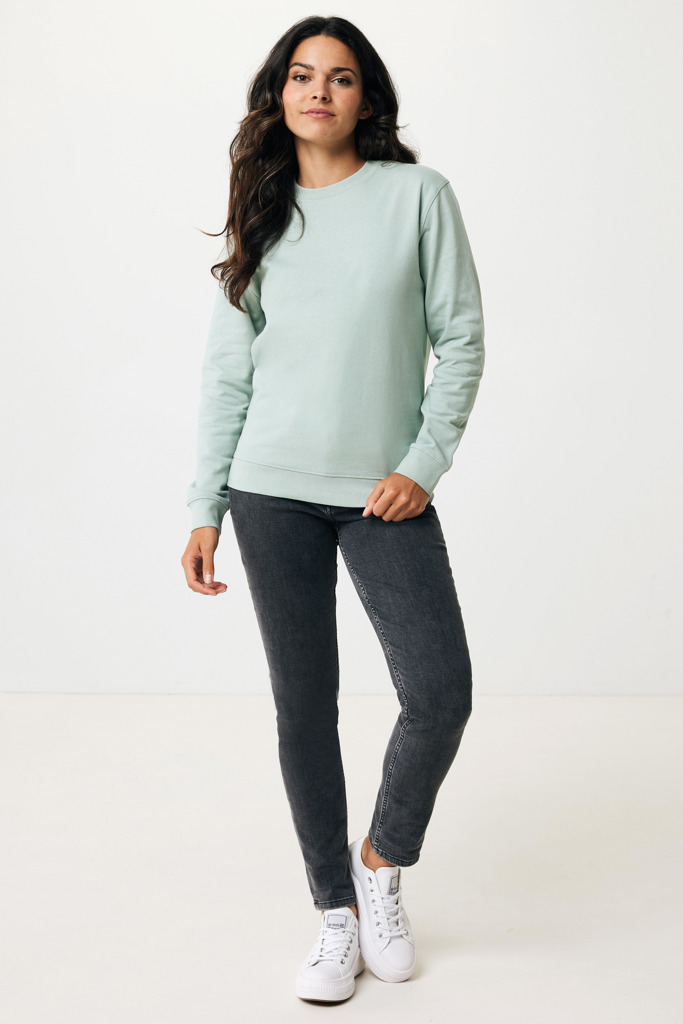 Femme portant un sweat vert et un jean noir