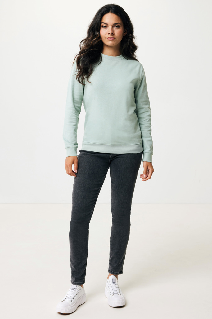 Femme portant un sweatshirt vert et jean noir