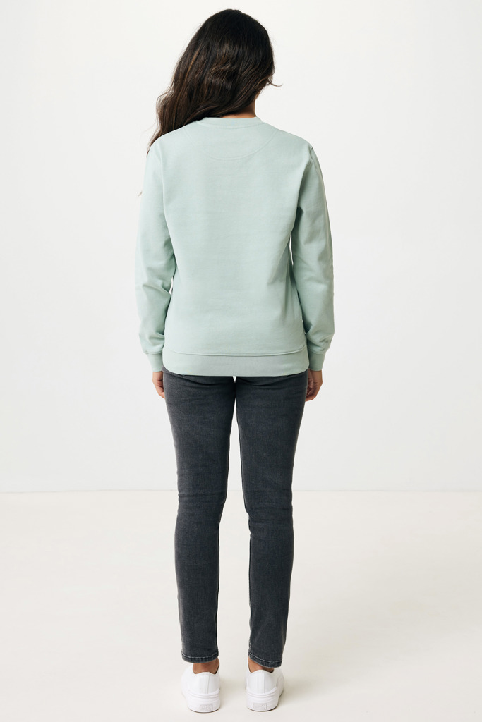 Personne portant un sweat vert et jean gris.