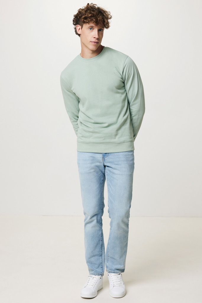 Homme portant un pull vert et un jean clair