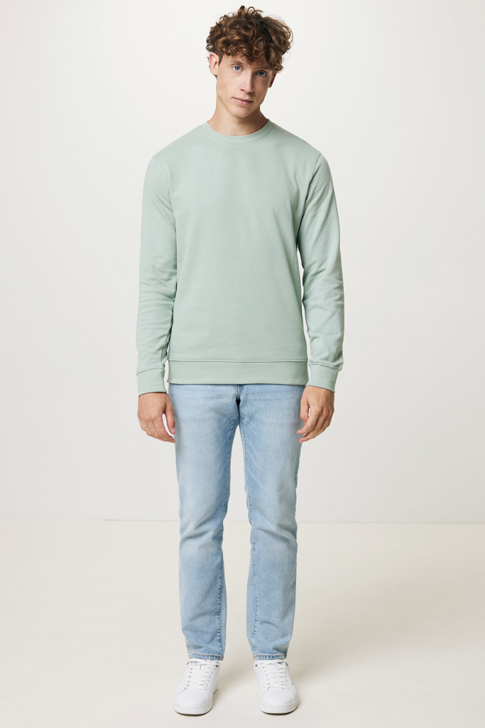 Homme portant pull vert clair et jean bleu