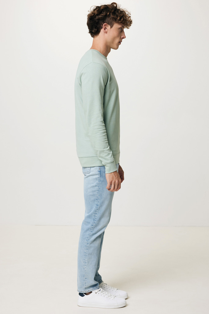 Homme portant un sweat vert et jean clair