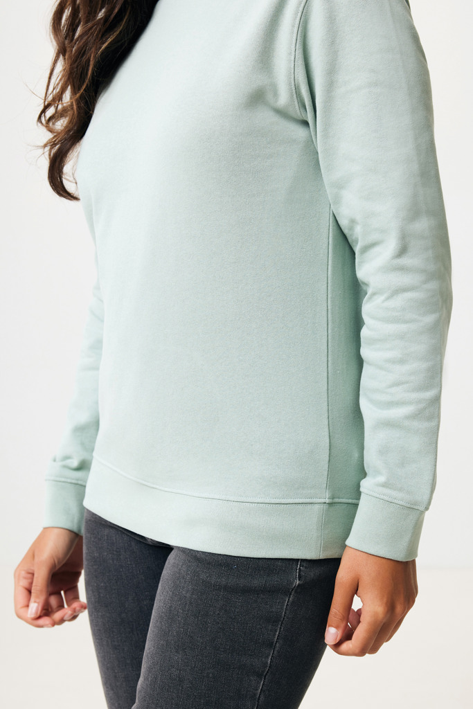 Personne portant un sweat vert clair et jean noir