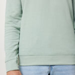 Homme portant un sweat vert clair et jean bleu