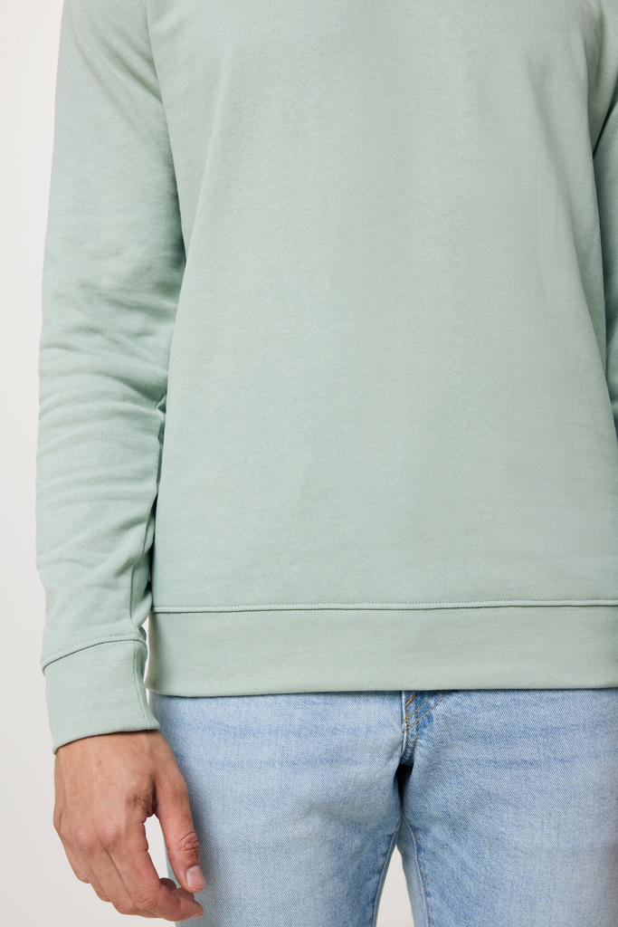 Homme portant un sweat vert clair et jean bleu