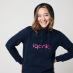 Personne souriante portant un sweat iqoniq bleu marine