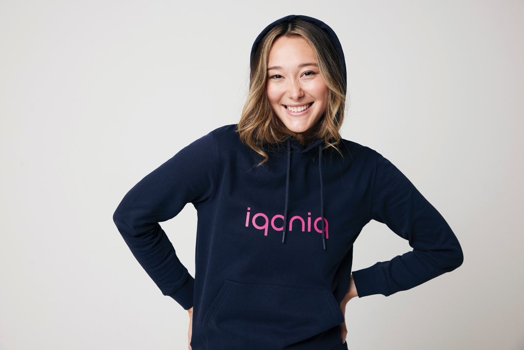 Personne souriante portant un sweat iqoniq bleu marine