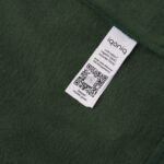 Étiquette blanche sur tissu vert foncé.