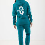 Femme portant un survêtement turquoise Essentials