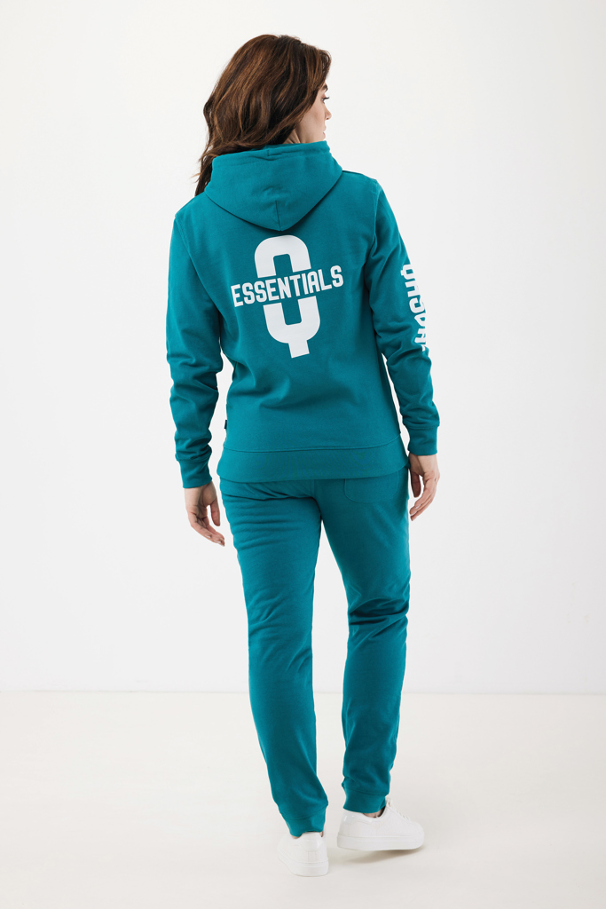 Femme portant un survêtement turquoise Essentials