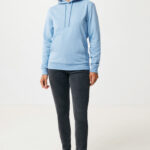 Femme portant un sweat bleu clair et jean noir.