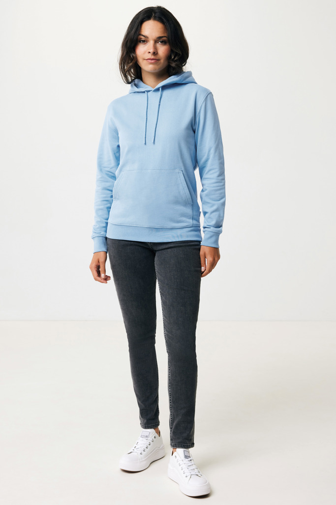 Femme portant un sweat bleu clair et jean noir.