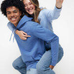 Ami portant une amie souriante en sweat bleu.