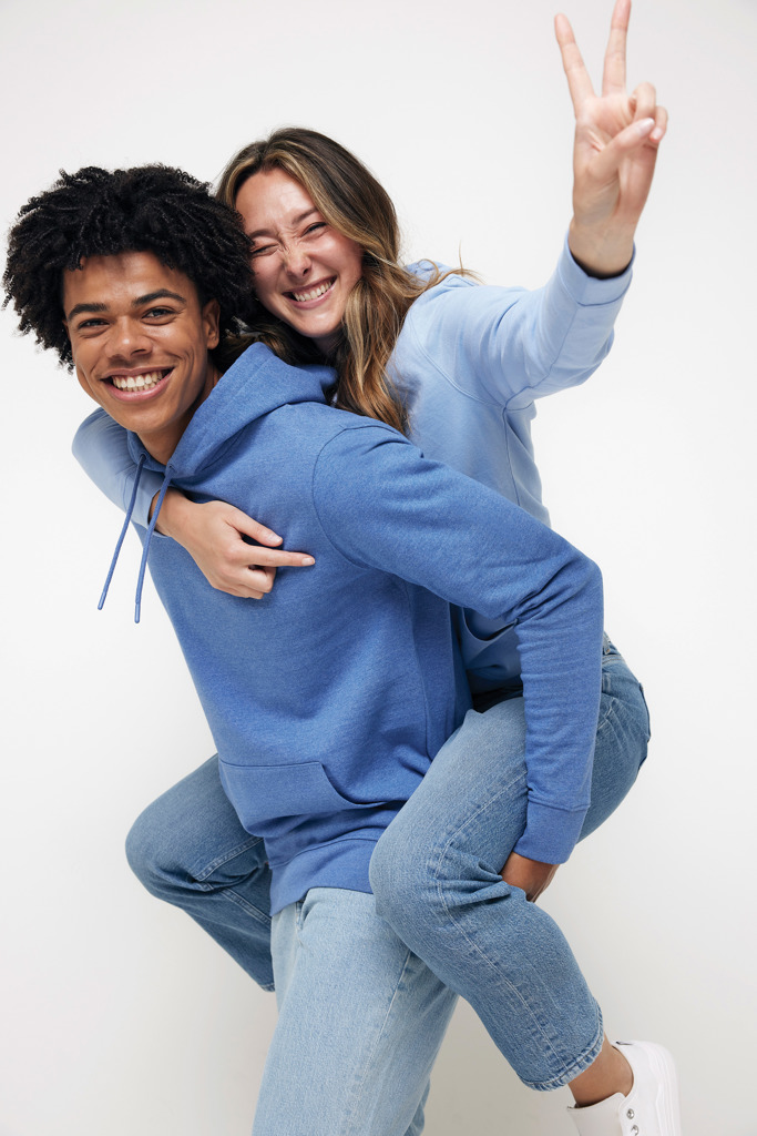 Ami portant une amie souriante en sweat bleu.