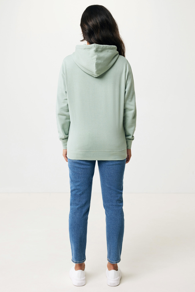 Personne portant un sweat vert et un jean bleu