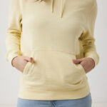 Personne portant un sweat à capuche jaune pâle.