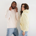 Deux personnes portent des sweats à capuche colorés.