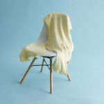Sweat jaune posé sur une chaise blanche