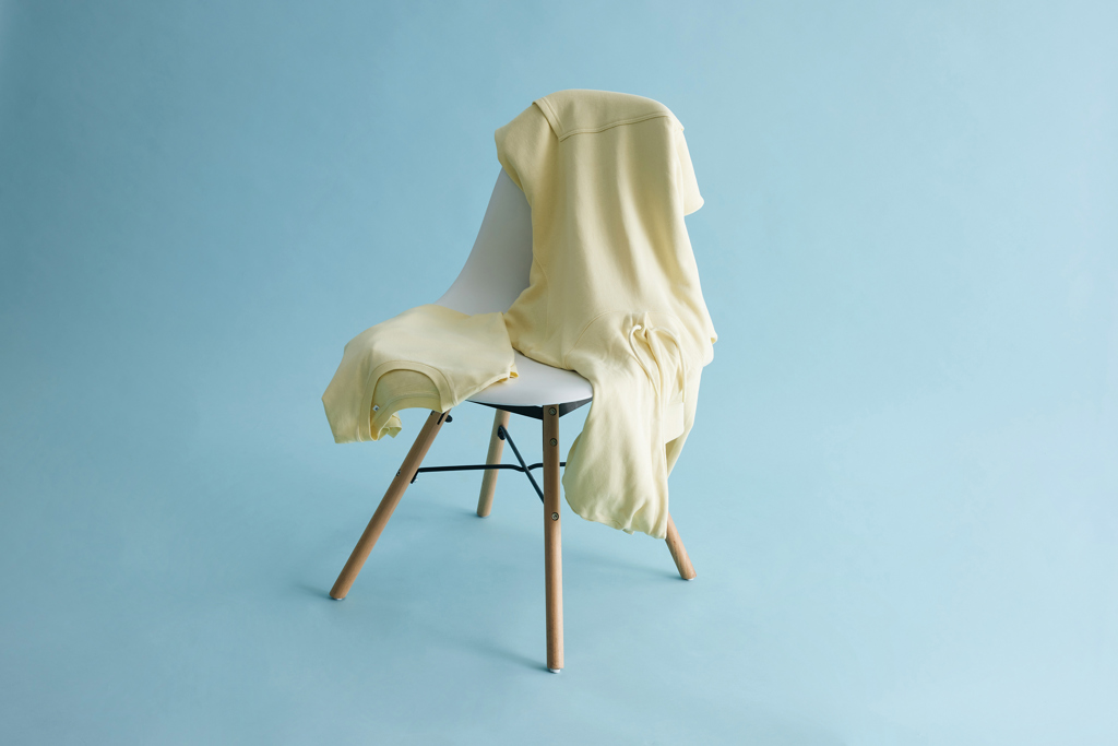 Sweat jaune posé sur une chaise blanche