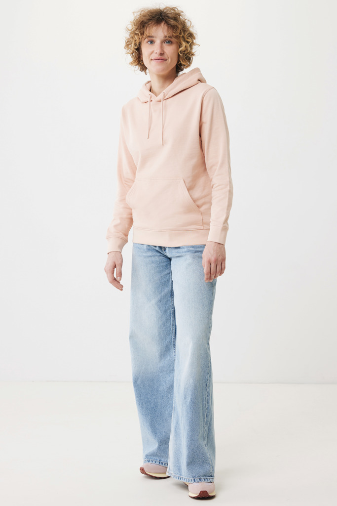 Personne portant un sweat rose et jean clair.