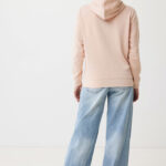 Personne portant un sweat rose et un jean large