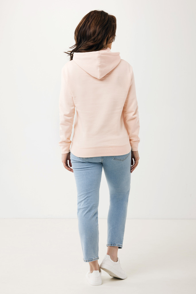 Personne portant un sweat rose et jean bleu.