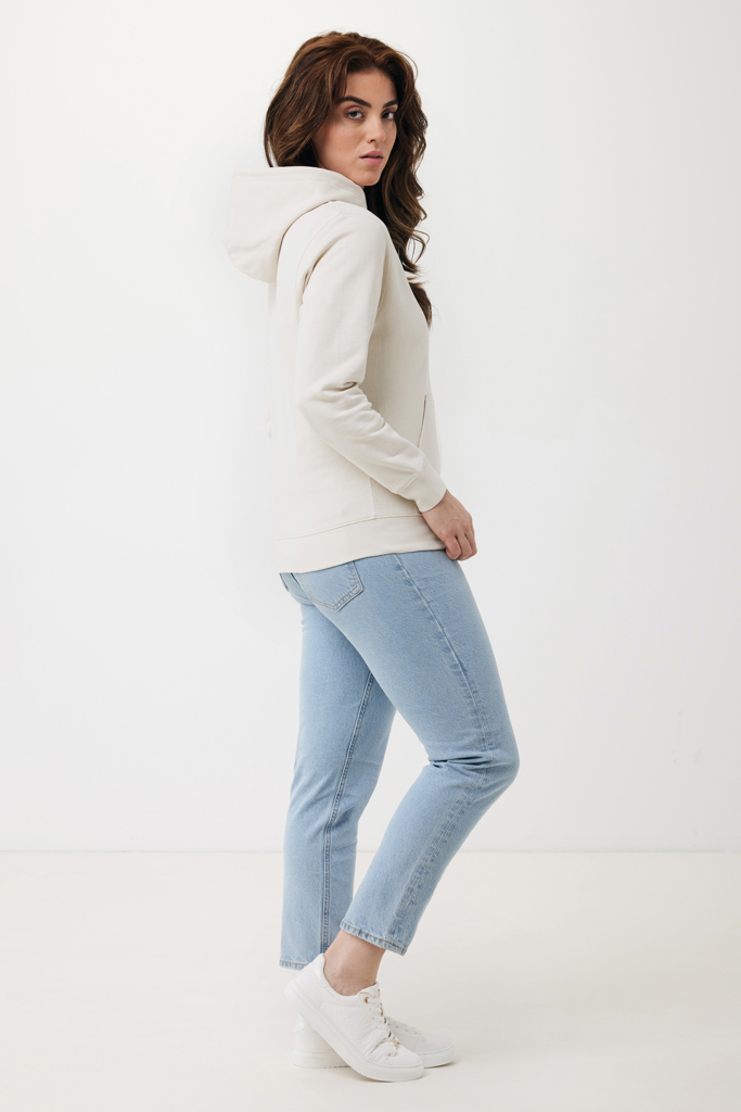 Femme portant un sweat beige et jean clair.