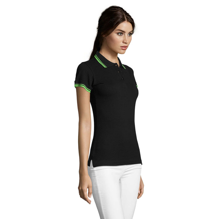Femme portant un polo noir et pantalon blanc