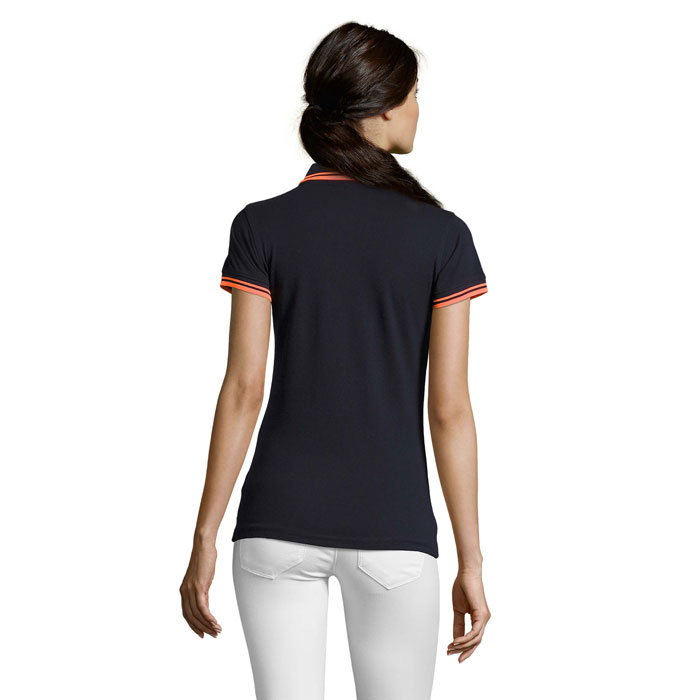 Femme portant un polo noir et pantalon blanc