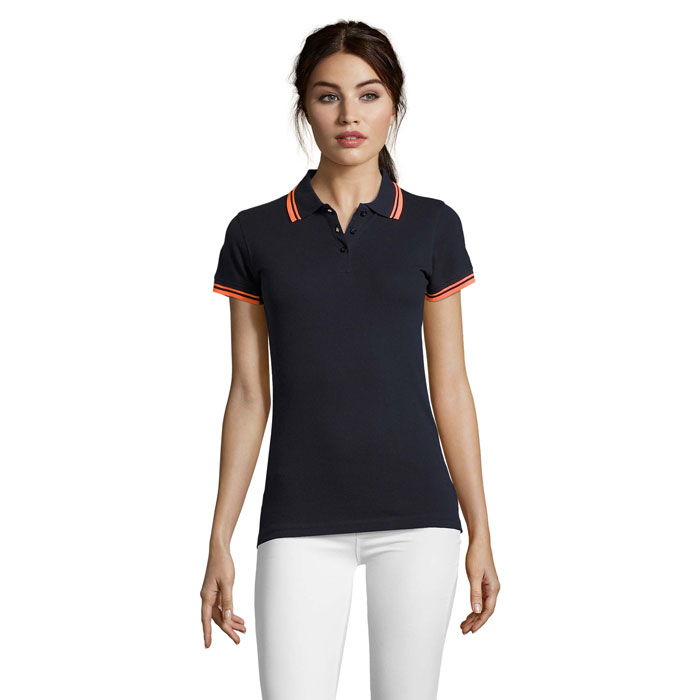 Femme portant un polo noir et pantalon blanc