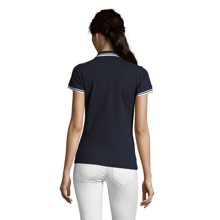 Femme portant un polo noir et pantalon blanc