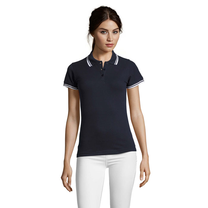 Femme portant un polo noir et pantalon blanc