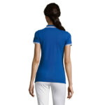 Femme portant un polo bleu et pantalon blanc