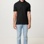 Homme portant polo noir et jean clair.