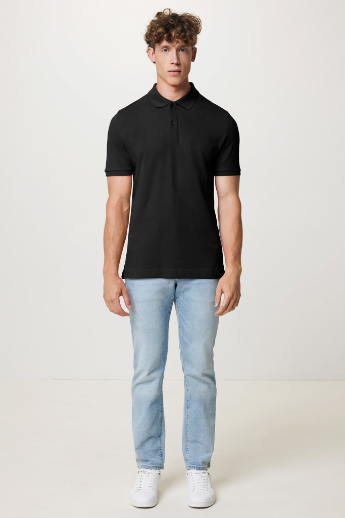 Homme portant polo noir et jean clair.