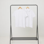 T-shirts blancs suspendus sur un portant noir