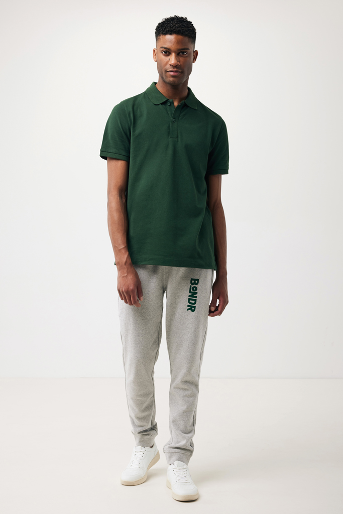 Homme portant polo vert et jogging gris